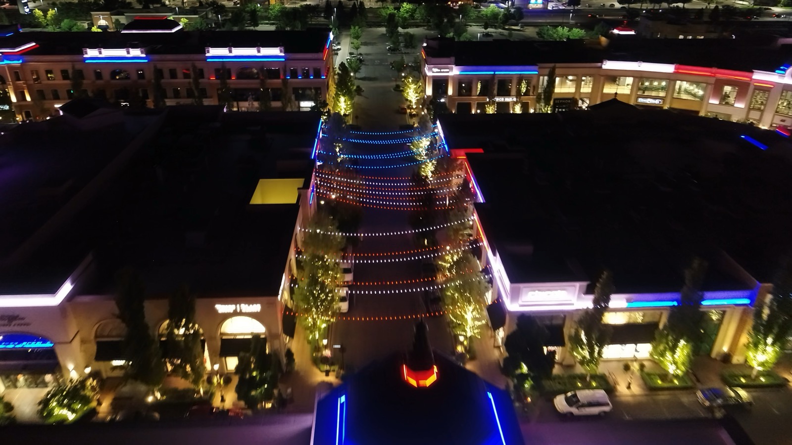 Festoon lighting spanning the promenade with full-color DMX façade outlines